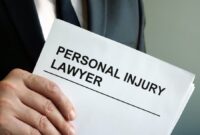 close-up-of-a-man-in-a-suit-holding-a-paper-that-says-personal-injury-lawyer.jpg